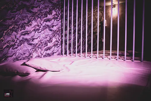 Espace coin câlin du 113 Avenue, club libertin à Eysines près de Bordeaux, lit et éclairage violet.