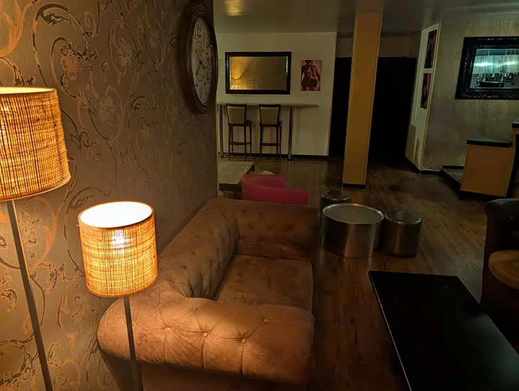 Salon cosy du 113 Avenue, sauna libertin à Bordeaux, espace détente et ambiance intimiste.